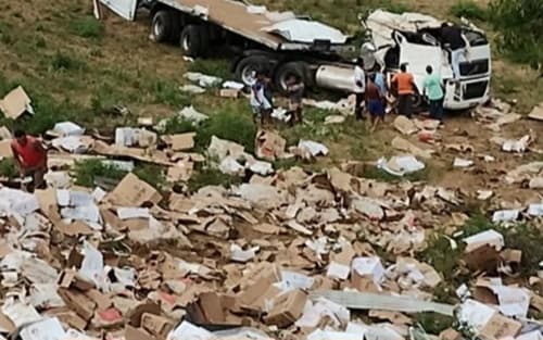 Carreta tomba na BR e carga de carne é saqueada por populares
