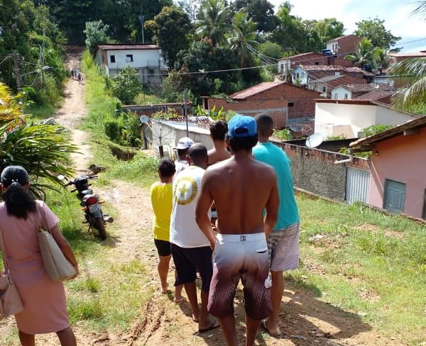 Moradora do bairro Irmã Dulce é carregada em cadeira por populares para atendimento médico