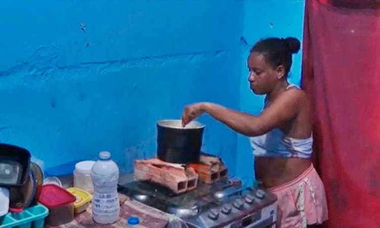 Mulher compra álcool combustível para cozinhar após aumento no preço do gás na Bahia