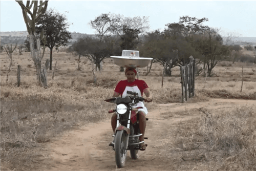 Confeiteira Baiana conquista fãs ao equilibrar bolos na cabeça em entregas de moto