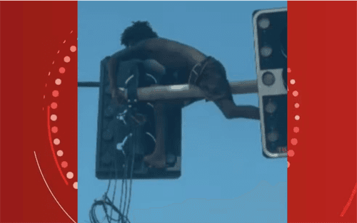 Homem se pendura em semáforo para furtar fios em Salvador