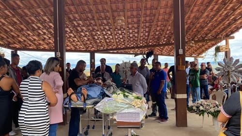 Deitada em maca, sobrevivente acompanha velório de filha em acidente com 24 mortos na Bahia
